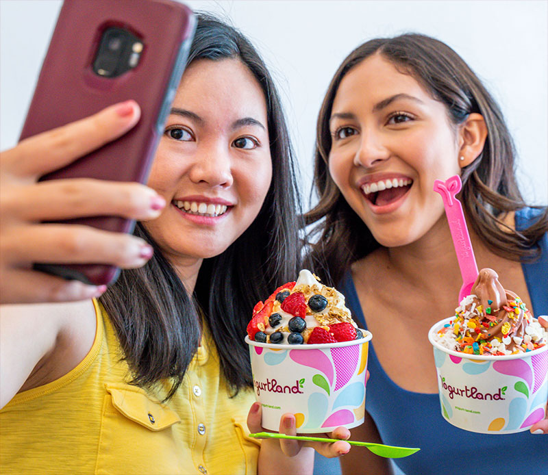 Two people enjoying Yogurtland frozen yogurt.