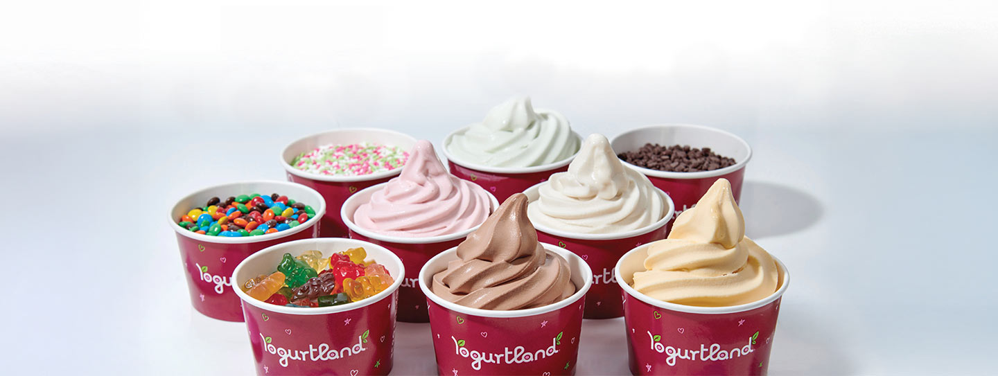 A group of Yogurtland cups of frozen yogurt and toppings