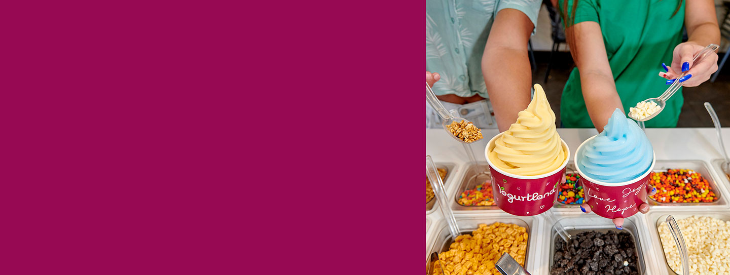 Two Yogurtland frozen yogurt cups with an assortment of toppings