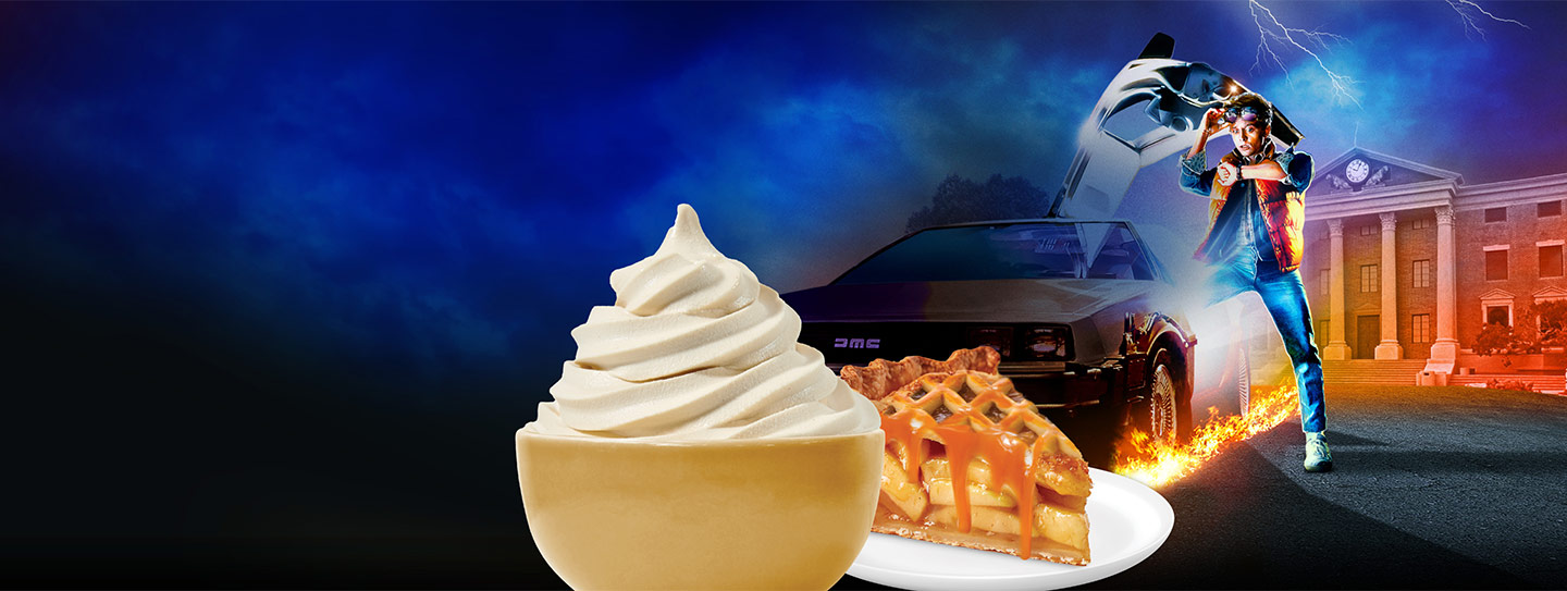A cup of frozen yogurt alongside a slice of apple pie with caramel sauce.