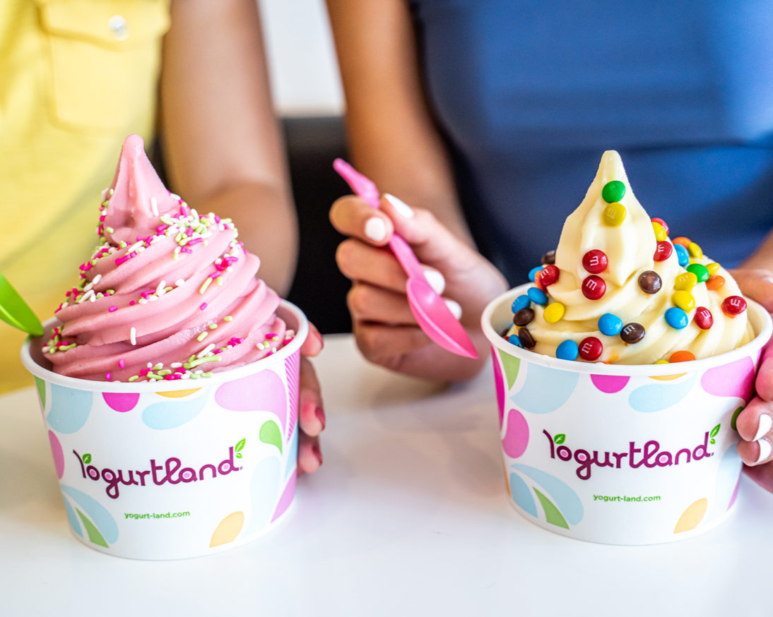 Two cups of frozen yogurt on a countertop.